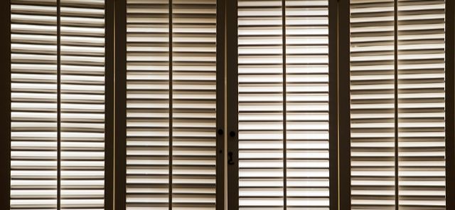 Dark Shutters Slightly Closed Allowing A Little Light Through.